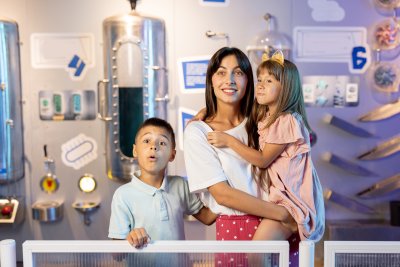 A mom with her son and daughter in a science museum.