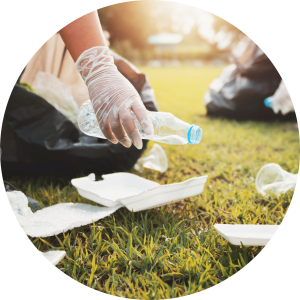 Photo depicting people wearing protective gloves and collecting litter from a grassy area