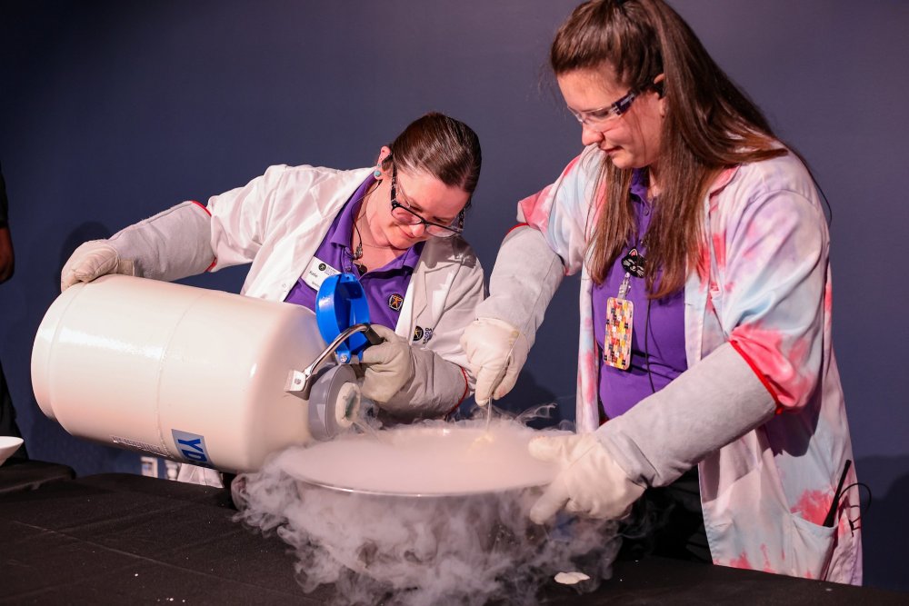 Two educators create ice cream using liquid nitrogen during a live science show.
