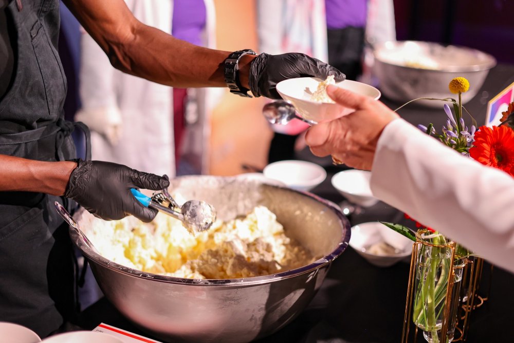 A staff member hands out ice cream made with liquid nitrogen during Super Cool Sundaes